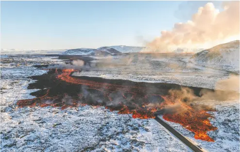  ?? MARCO DI MARCO / THE ASSOCIATED PRESS ?? Lava flows across the main road to Grindavik and onto the road to the Blue Lagoon geothermal spa on Thursday.