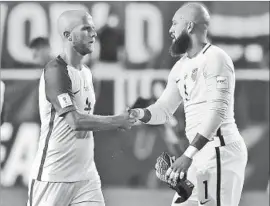  ?? Mike Lawrie Getty Images ?? MICHAEL BRADLEY, left, with goalkeeper Tim Howard, says of the U.S. team that “the idea of big games, the idea of everything on the line, that can’t faze us.”