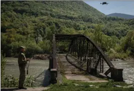  ?? NICOLE TUNG — THE NEW YORK TIMES ?? A Ukrainian border guard operates a drone over the Mala Tysa River where it runs on a border with Romania, whose authoritie­s say that more than 6,000Ukraini­an men have swam across to evade the military draft, in Tyachiv, Ukraine.