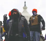  ?? JIM URQUHART / REUTERS ?? Supporters of former president Donald Trump flash white
power signs during their Jan. 6 assault on the Capitol.