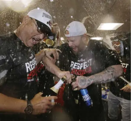  ?? ELISE AMENDOLA/THE ASSOCIATED PRESS ?? SURVIVAL OF THE WETTEST Indians (and former Red Sox) manager Terry Francona gets caught in the clubhouse spray with Mike Napoli after a 4-3 victory at Fenway Park on Monday night. Later, Francona talked about his respect for Red Sox DH David Ortiz, now...