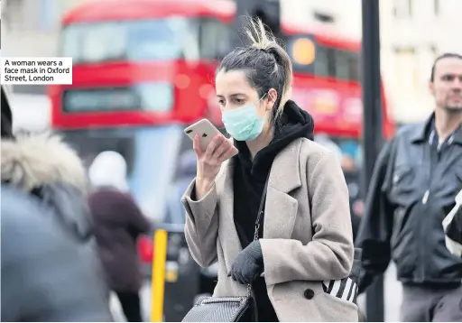  ??  ?? A woman wears a face mask in Oxford Street, London