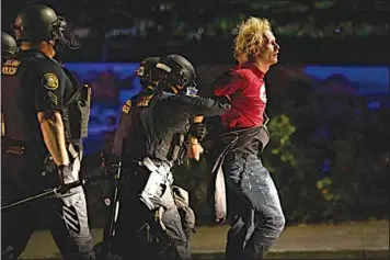  ?? PAULA BRONSTEIN, AP FILE ?? In this Aug. 30, 2020, file photo, police make arrests on the scene of protests at a Portland police precinct on in Portland, Ore.
