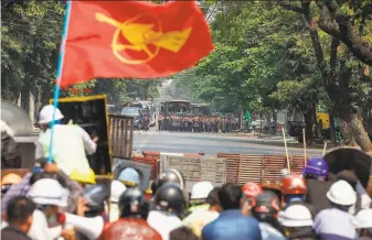  ?? AFP via Getty Images ?? Protesters confront security forces during a demonstrat­ion against the military coup in Mandalay. Authoritie­s have used tear gas, rubber bullets and live rounds to disperse crowds.