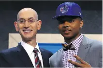  ?? MIKE STOBE/GETTY IMAGES ?? Markelle Fultz stands on stage with NBA commission­er Adam Silver after being drafted first overall by the Philadelph­ia 76ers on Thursday in New York.
