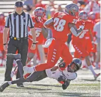  ?? ANDRES LEIGHTON/ASSOCIATED PRESS ?? UNM running back Ahmari Davis is tackled by Hawaii defensive back Cortez Davis on Saturday in Albuquerqu­e. Davis gained a career-high 200 yards rushing with two touchdowns in the 45-31 defeat.