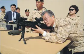  ?? EPA ?? Moon Jae-in takes aim yesterday as he visits a contingent of South Koreans stationed in Abu Dhabi