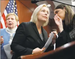  ?? JACQUELYN MARTIN — THE ASSOCIATED PRESS ?? Sen. Kirsten Gillibrand, D-N.Y., center, listens to a staffer before answering questions at a news conference Tuesday on Capitol Hill in Washington.