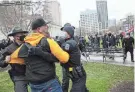  ?? JOSHUA A. BICKEL/COLUMBUS DISPATCH ?? Law enforcemen­t officers restrain a member of the Proud Boys during a “Stop the Steal” rally on Jan. 6, 2021, at the Ohio Statehouse in Columbus.