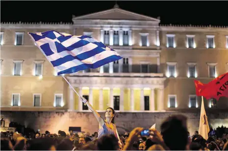  ?? Foto: Emilio Morenatti, AP ?? Vlajka hrdě vlaje Řekové slavili své ne po celé zemi, centrem oslav se staly tradičně Atény.