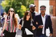  ?? Matt Rourke / Associated Press ?? Former NFL players Ken Jenkins, right, and Clarence Vaughn III, center right, along with their wives, Amy Lewis, center, and Brooke Vaughn, left, carry tens of thousands of petitions demanding equal treatment for everyone involved in the settlement of concussion claims against the NFL, to the federal courthouse in Philadelph­ia on May 14, 2021.