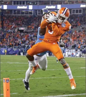  ??  ?? Clemson’s Artavis Scott, front, catches a touchdown pass as North Carolina’s Donnie Miles defends.