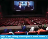  ??  ?? People sit in the screening room as they wait for the start of a movie at the Majestic cinema.