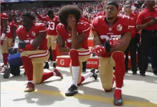  ?? BAY AREA NEWS GROUP FILE PHOTO ?? From left, 49ers’ Eli Harold, Colin Kaepernick and Eric Reid kneel during the anthem before a game last October.