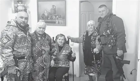  ?? ALEXANDER DEMICH ?? Maria Stasenko, second from right, stands next to her grandson, preparing to fight with Ukrainian forces.