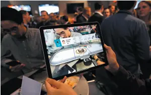  ?? AP PHOTO ?? A fan uses a tablet for tracking a game between the Vegas Golden Knights and San Jose Sharks in Las Vegas on Thursday.