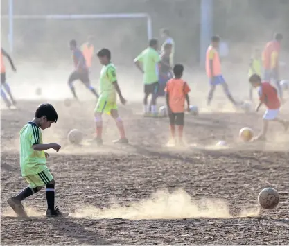  ??  ?? Indian boys get their daily dose of football training in their neighbourh­ood coaching camp in Mumbai.