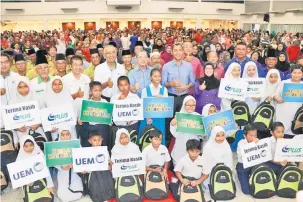  ??  ?? BANTU: Fadillah ditemani Fazzrudin dan Azman merakam kenangan bersama pelajar yang menerima bantuan sekolah.