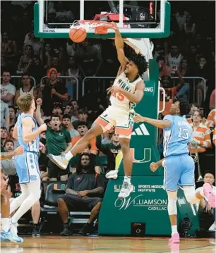  ?? REBECCA BLACKWELL/AP PHOTOS ?? Miami forward Norchad Omier dunks past North Carolina forward Jalen Washington during the first half of Saturday’s game in Coral Gables.