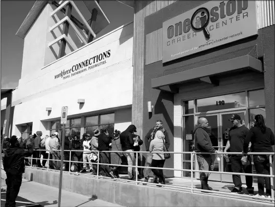  ?? JOHN LOCHER / ASSOCIATED PRESS FILE (2020) ?? People wait in line for help with unemployme­nt benefits March 17, 2020, at the One-stop Career Center in Las Vegas.