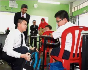  ??  ?? Chong listening intently as a pupil shares his feedback at SJKC Broga on the first day of the UPSR exam. Making his rounds: