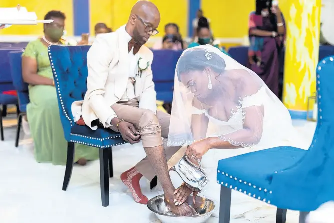  ?? CONTRIBUTE­D PHOTOS ?? Andrea Edwards washes the feet of her husband, Markland, during their wedding ceremony.