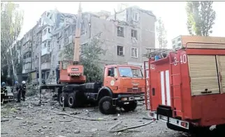  ?? /Reuters ?? Attacks intensify: Rescuers work at a residentia­l building hit by a Russian military strike on Wednesday in Mykolaiv, killing at least three civilians. Moscow says its forces hit what it called a training base for foreign mercenarie­s.