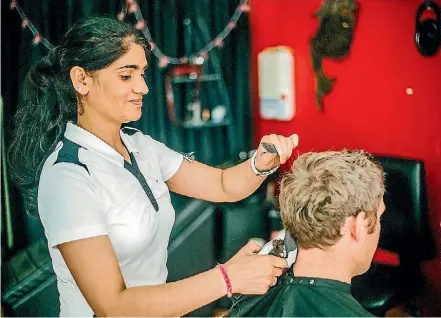 ??  ?? Headmaster’s Barbershop owner Kuldip Kaur doing what she loves best.