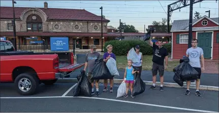  ?? SUBMITTED PHOTO — COURTESY OF BJ BREISH ?? Lansdale residents carry bags of trash gathered on and around the borough’s Railroad Plaza during a cleanup event on Wednesday night, June 30. From left to right are residents Bruce Schwartz, Denise O’Hara, Addison Breish, Helen Schwartz, Bill Henning and Jacob Curlett.