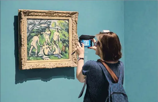  ?? MANÉ ESPINOSA ?? Una visitant fotografia amb el mòbil Cinc banyistes, de Paul Cézanne, una obra que després va formar part de la col·lecció de Picasso