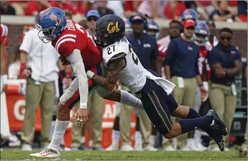  ?? THOMAS GRANING — THE ASSOCIATED PRESS ?? California safety Ashtyn Davis (27) tackles Mississipp­i quarterbac­k Matt Corral during a game last season.