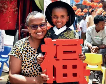  ?? (XINHUA) ?? Local people pose for a photo with Chinese character Fu, which means good fortune, during the Nairobi Chinese New Year Gala in Nairobi, Kenya, on 10 February