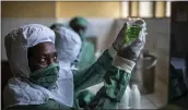  ??  ?? Workers wearing protective clothing to protect from the effects of the drug and to prevent contaminat­ion, make liquid morphine from powder which is dyed green as a color-code to indicate the strength, at the Pharmaceut­ical Laboratory of Rwanda in Butare, Rwanda.