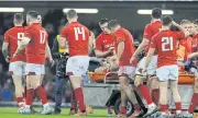  ??  ?? Wales’ Ellis Jenkins is checked on by teammates as he is carried from the field.