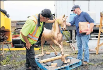  ?? ERIC BOURQUE ?? Stan Churchill, of All-Out Property Services, and Todd Muise, the Town of Yarmouth’s parks co-ordinator, inspect the Milton horse after it was returned to Yarmouth following repairs. The horse is part of a historic landmark fountain in the town that dates back to 1893.