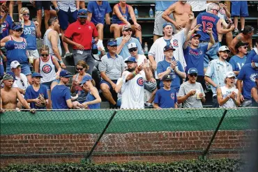  ?? BRIAN CASSELLA / CHICAGO TRIBUNE ?? “Mai Tai Guy” (front row in white jersey) is accused of swiping Kyle Schwarber’s walk-off home run against the Reds from two young boys who were reaching into the basket for the game-winning ball.