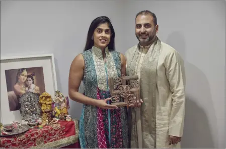  ?? PHOTOS BY ANDRES KUDACKI — THE ASSOCIATED PRESS ?? Sheetal Deo and her husband, Sanmeet Deo, hold a Hindu swastika symbol in their home in Syosset, N.Y., on Nov. 13.