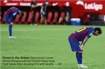  ??  ?? Down in the dumps: Barcelona’s Lionel Messi (foreground) and Gerard Pique hang their heads after drawing 0-0 with Sevilla. — aP