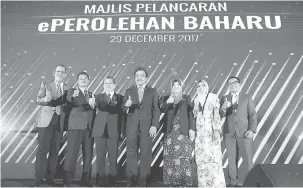  ?? — Gambar Bernama ?? UNTUK KENANGAN: Johari (tengah) bergambar kenangan pada Majlis Pelancaran Sistem ePerolehan Baharu di Kompleks Kementeria­n Kewangan semalam. Turut kelihatan Timbalan Ketua Setiausaha Bahagian Dasar Kementeria­n Kewangan Datuk Siti Zauyah Md Desa (dua,...