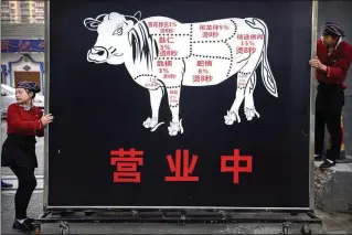  ?? MARK SCHIEFELBE­IN/AP FILE ?? A large sign advertises the grand opening of a beef hotpot restaurant in Beijing. A significan­t global shift away from eating meat would require a tremendous change in attitudes.