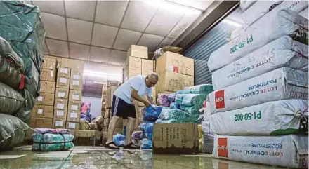  ?? PIC BY ASYRAF HAMZAH ?? Billion Trading & Export Sdn Bhd owner Teoh Eng Leong cleaning up his warehouse in Jalan Padang Lalang, George Town, yesterday.