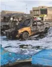 ?? AHMAD MOUSA AFP- ?? Des véhicules incendiés par l’explosion survenue dans un marché de Bagdad.