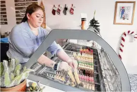  ?? Ned Gerard/Hearst Connecticu­t Media ?? Chef Christina Schumacher lays paletas into a display freezer at the start of the day at Dave’s Gourmet Paletas in Shelton.