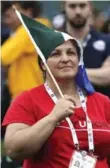  ??  ?? Therese Lindsay, a staff member of the Yukon team, protects herself from the rain with a flag during the closing ceremony at York University last night. The event featured singing, dancing and speeches.