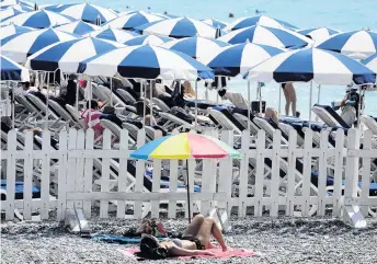  ?? PHOTO: REUTERS ?? The heat is on . . . A woman sunbathes on the beach as extreme temperatur­es hit Nice, France, this week