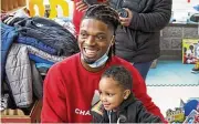  ?? MATT FREED / PITTSBURGH POST-GAZETTE ?? Damar Hamlin poses with Bryce Williams, 3, after the youngster picked out a toy during Hamlin’s Chasing M’s Foundation community toy drive, Dec. 22, 2020, in McKees Rocks, Pa.