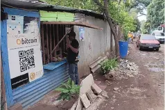  ??  ?? Santos Hilario Galvez, a Salvadoran who works as a builder at Hope House, an organizati­on that sponsors the use of cryptocurr­encies in the village of El Zonte, makes a purchase at a small store that accepts bitcoin, in Tamanique, El Salvador, on Wednesday.