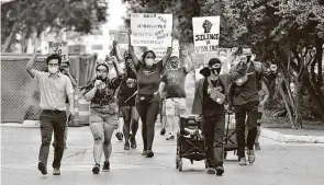  ?? Robin Jerstad / Contributo­r ?? Activists walk along Santa Rosa Street during the Jericho March on Saturday. Protesters marched from Columbus Park to the SAPD headquarte­rs and later to the Sheriff's Office.