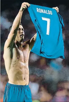  ?? STRINGER / AFP ?? Cristiano muestra su camiseta, como hizo Messi en el Bernabeu