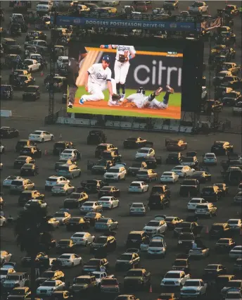  ?? SHUTTERSTO­CK ?? Fans remotely watch Game 2 of the World Series. The Los Angeles Dodgers bested the Rays to win the series in Game 6 on Tuesday (Oct. 27) at Globe Life Field in Arlington, Texas.